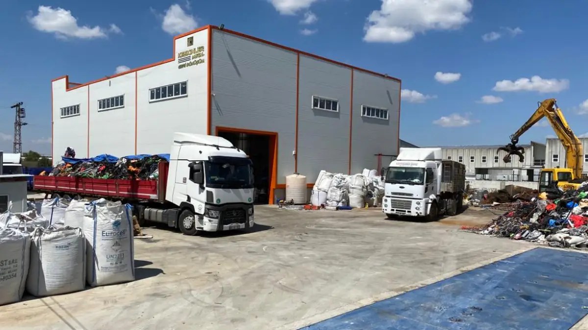 Tesis sahasında yükleme bekleyen kamyonlar ve kapalı üretim binası